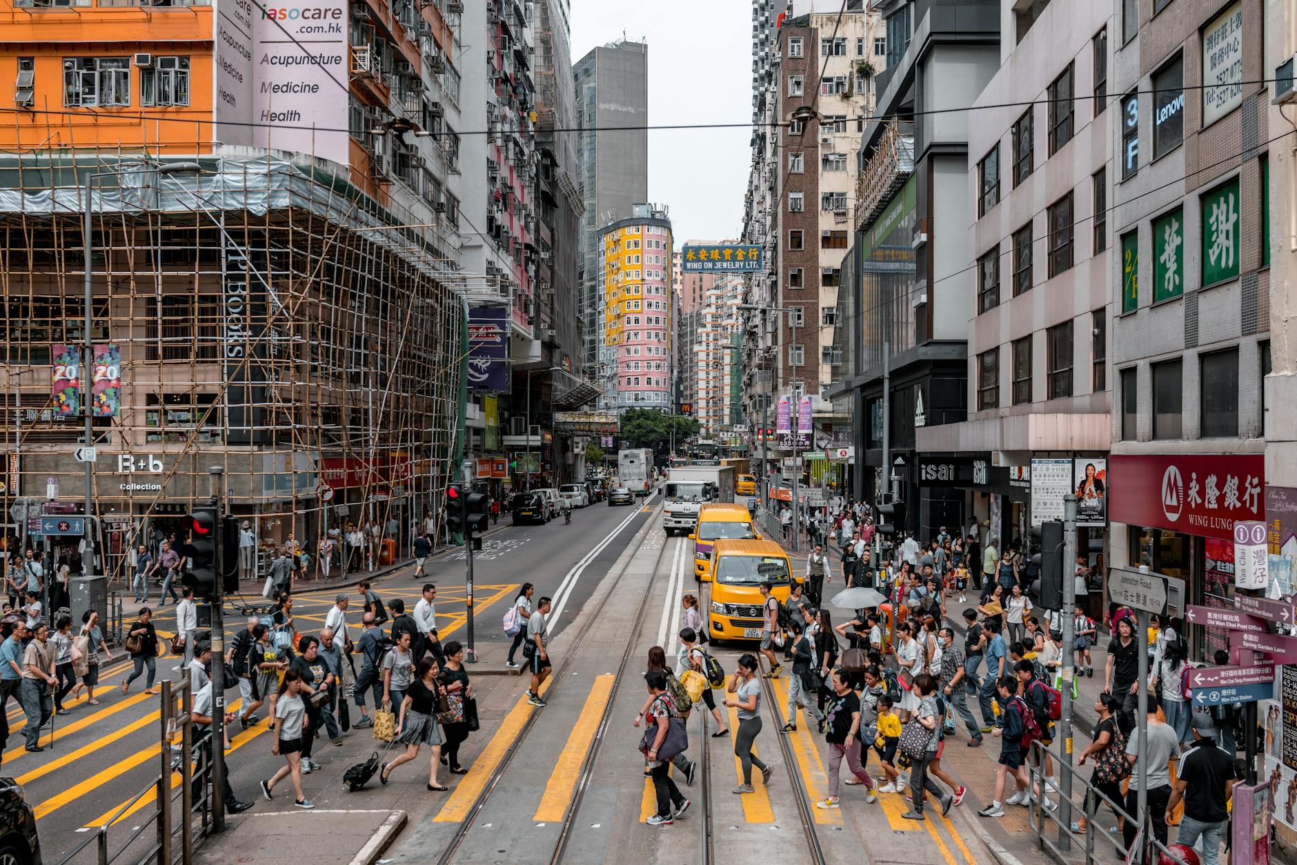 Hong Kong locals walking through a busy city street, showing everyday life from a local perspective